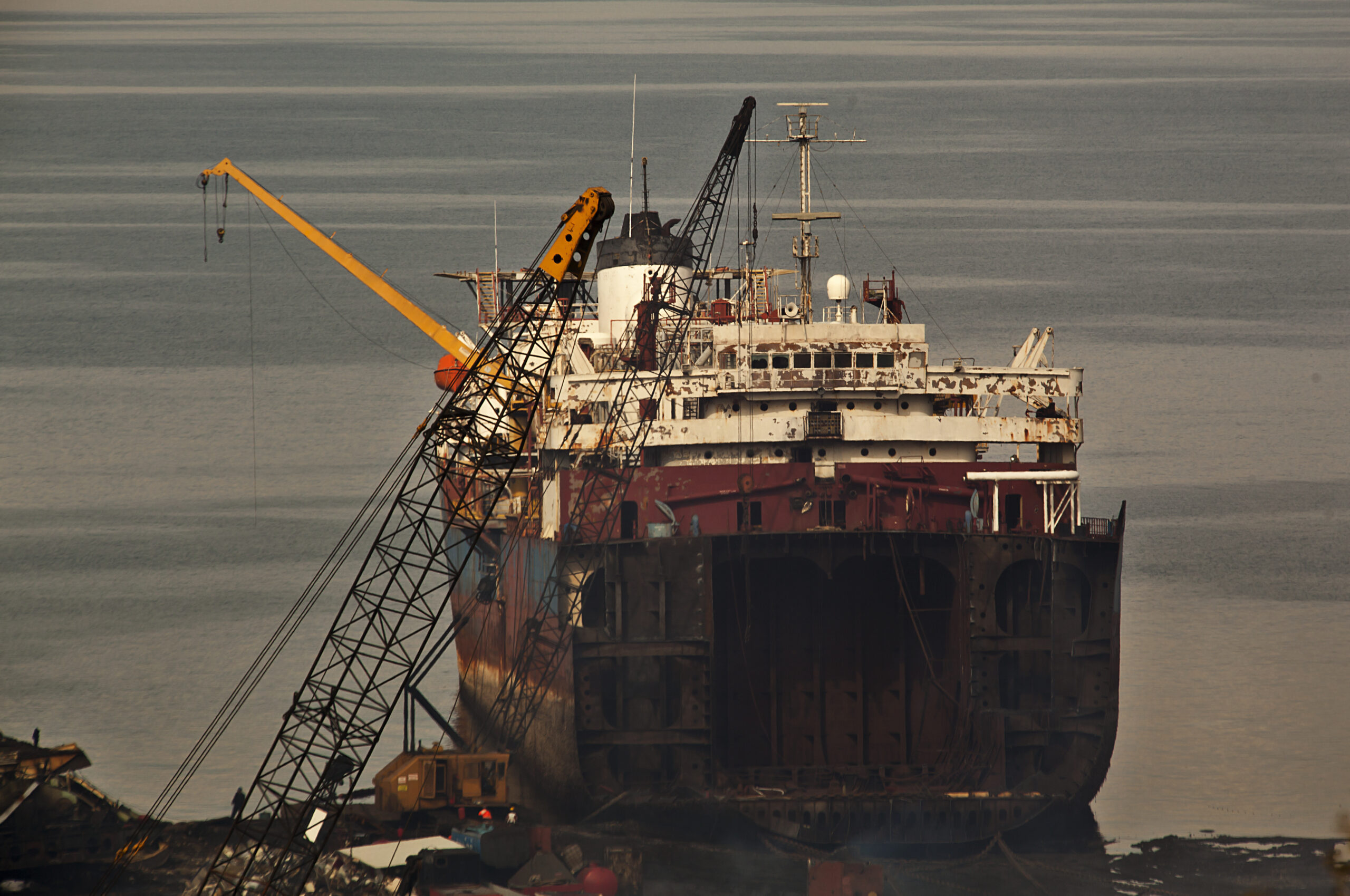 A large, rusted ship under repair