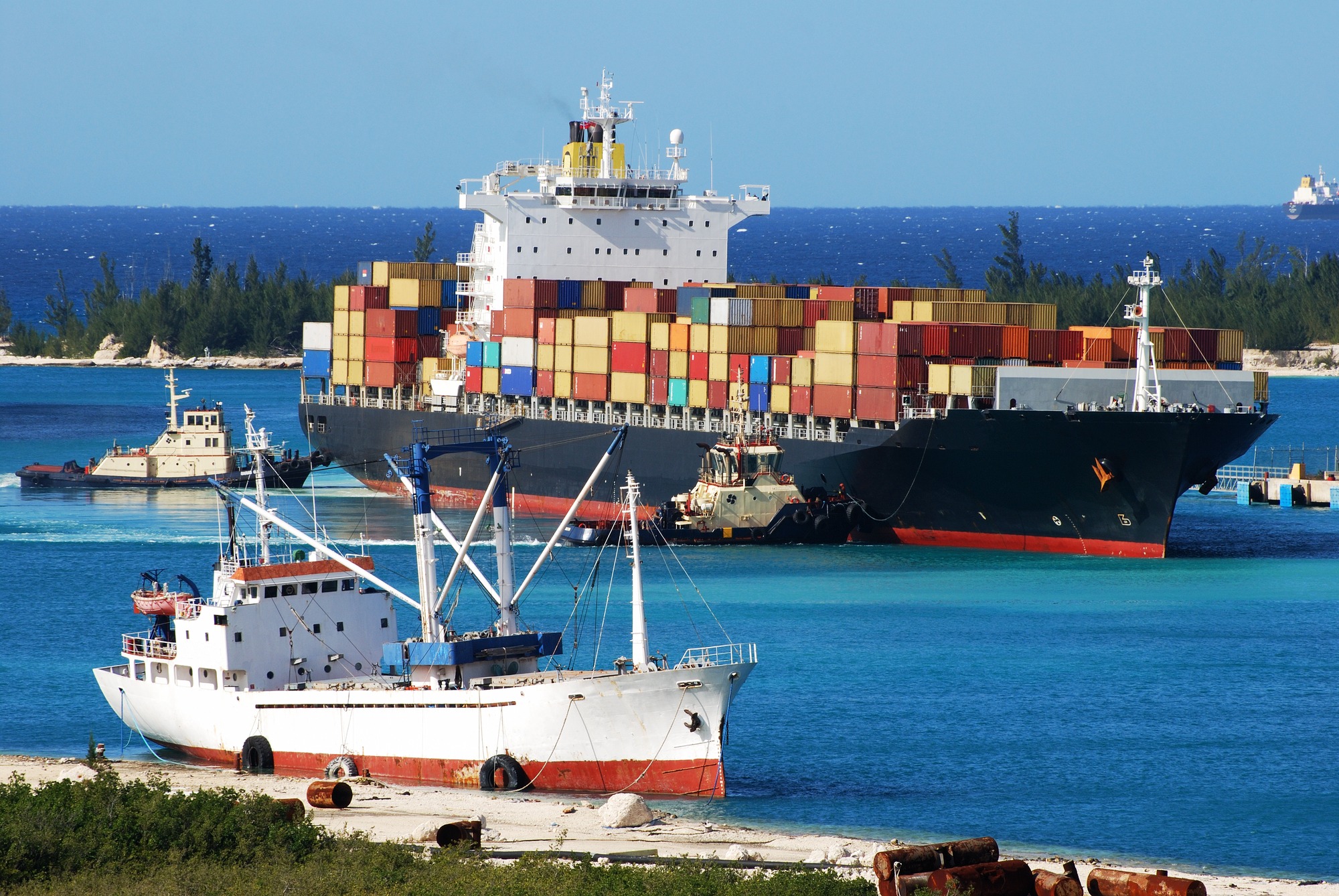 A large container ship unloads cargo in a harbor