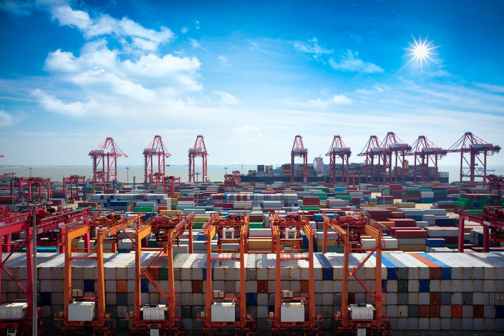 Vibrant cargo port with colorful shipping containers and red cranes